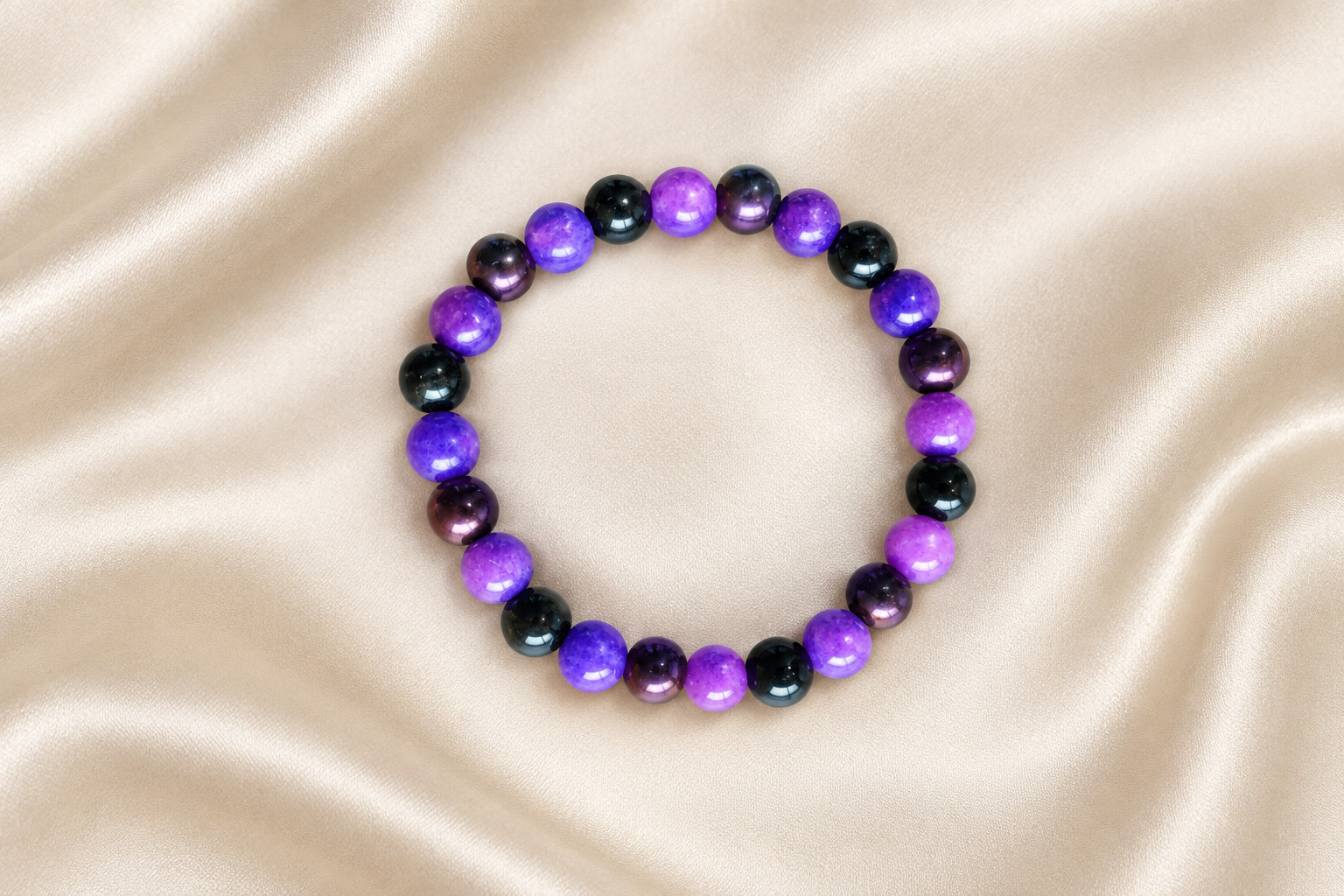 Pulseira de sugilite, hematite violeta e obsidiana dourada sobre cetim claro